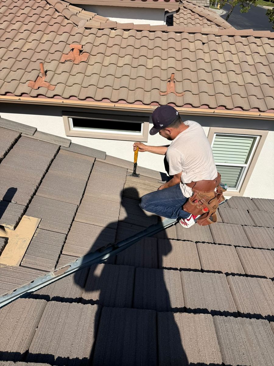 Roofer repairing a concrete tile roof